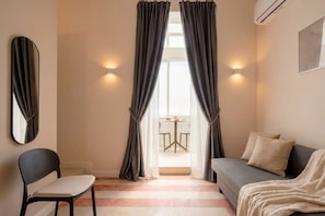 A room with a bed, a chair, a table, and curtains. - City Hub 6 | Historic Elegance & Modern Comfort in Bari (Bari)