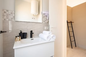 A modern bathroom with a white sink, a towel rack, and a hairdryer. - City Hub 6 | Historic Elegance & Modern Comfort in Bari (Bari)