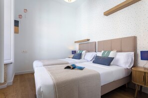 Un lit double avec une tête de lit, des tables de chevet et un mur orné d’un motif étoilé.