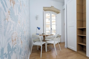 A room with a dining table, chairs, a lamp, a wall-mounted sculpture, and a wooden cabinet. - Genteel Home House of the 12 Balconies (Almeria)