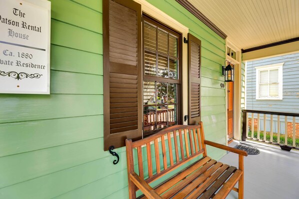 Una casa de madera verde con un cartel que indica que es una propiedad de alquiler desde 1880.