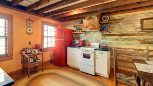 Eine Küche mit Holzbalken, einem roten Kühlschrank, einem weißen Herd und einer Backsplash mit Fischgrätmuster.