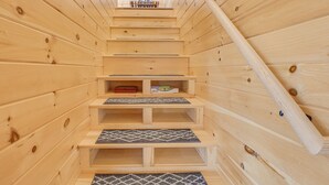Een houten interieur met een trap naar een vide.