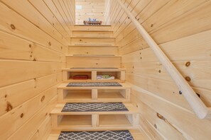 A wooden interior with a staircase leading to a loft area.