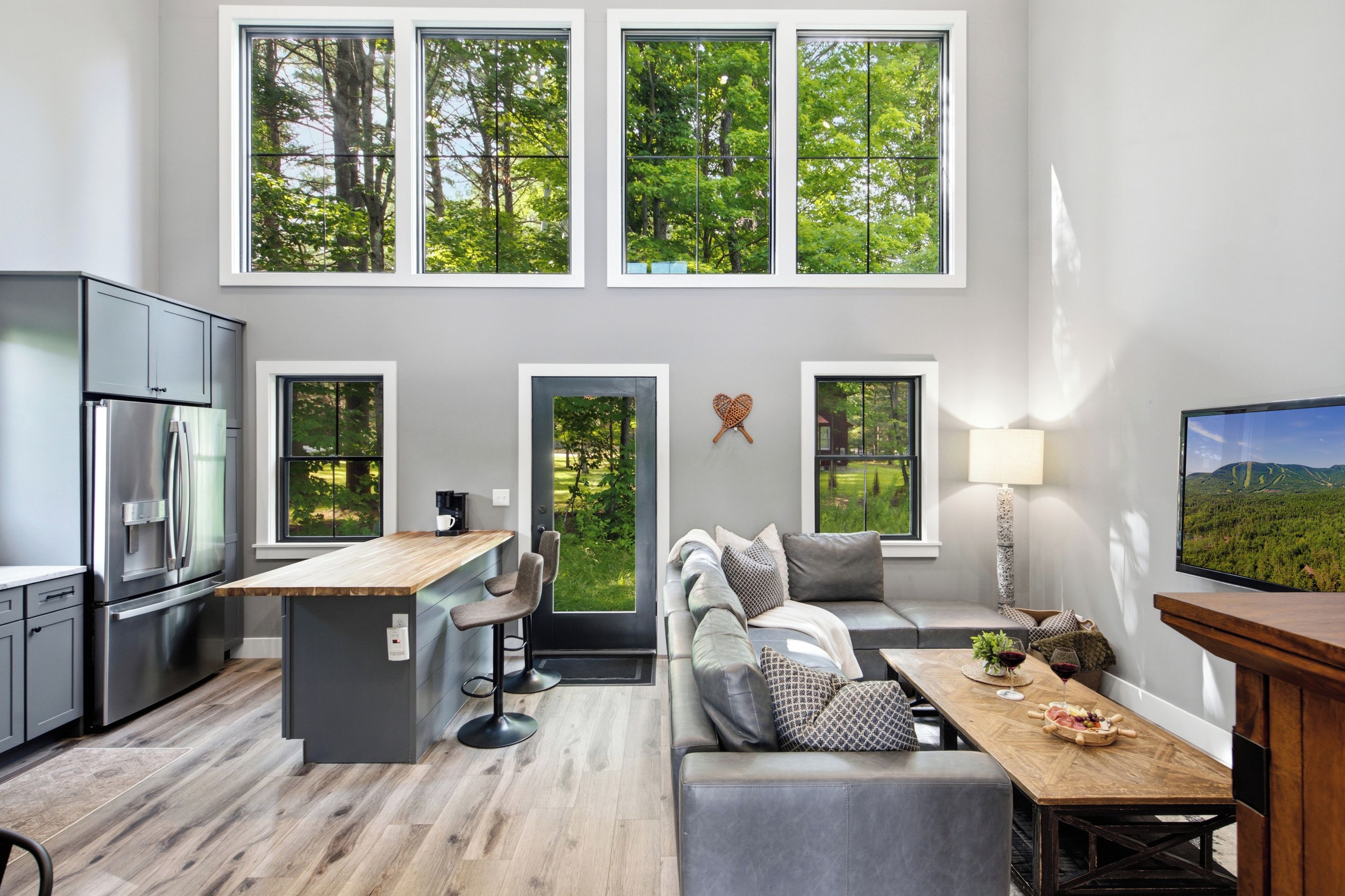 A modern kitchen with a built-in refrigerator and a dining area with a wooden table and chairs.