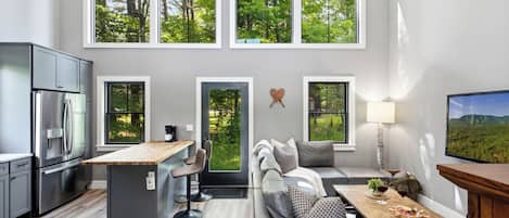A modern kitchen with a built-in refrigerator and a dining area with a wooden table and chairs.