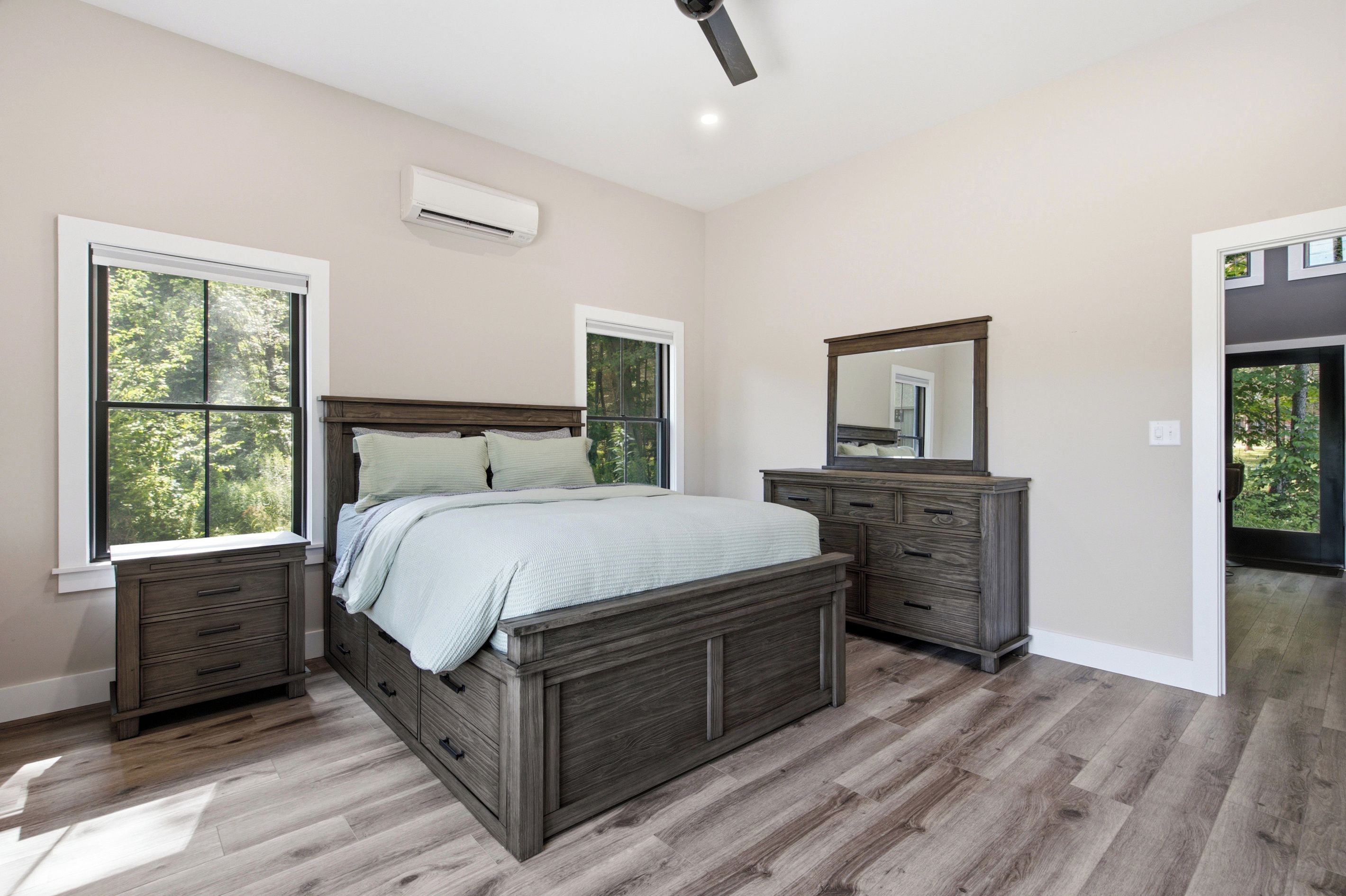 Une chambre à coucher avec un lit, une commode et un miroir.