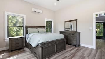 Une chambre à coucher avec un lit, une commode et un miroir.