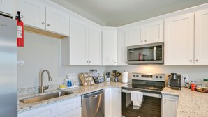 A modern kitchen with white cabinets, stainless steel appliances, a dishwasher, a microwave, and a coffee maker. - Great for Groups! 2 Centrally Located Concord Gems (Concord)