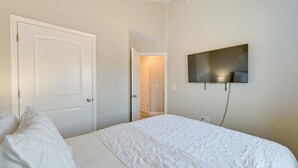A bedroom with a large bed, a television mounted on the wall, and a door leading to another room. - Great for Groups! 2 Centrally Located Concord Gems (Concord)