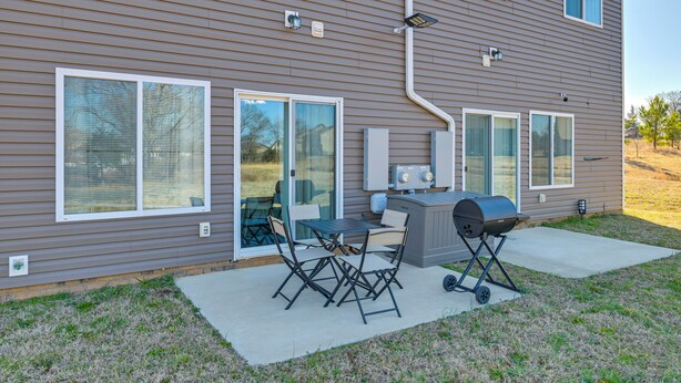 A residential house with a patio area featuring a grill, outdoor table, and chairs. - Great for Groups! 2 Centrally Located Concord Gems (Concord)
