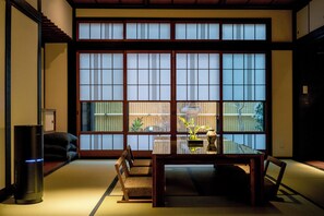 Une pièce de style japonais traditionnel, avec un sol recouvert de tatamis, une table basse et un canapé.