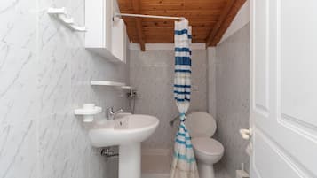 A bathroom with a white sink, a toilet, and a shower curtain.