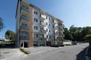 A multi-story residential building with balconies, a gated entrance, and a paved driveway. - Circle Bike Residence by Rent All Como. (Tavernerio)