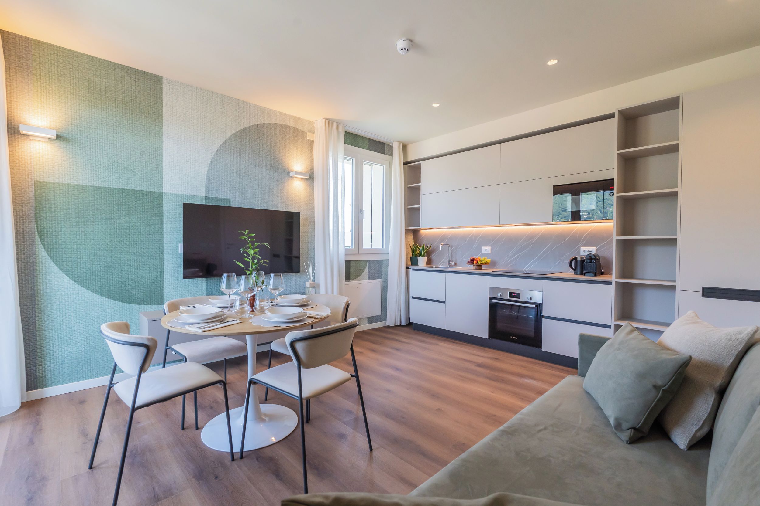 Ein modernes Wohnzimmer mit Essbereich, Küche und Sitzgelegenheit.