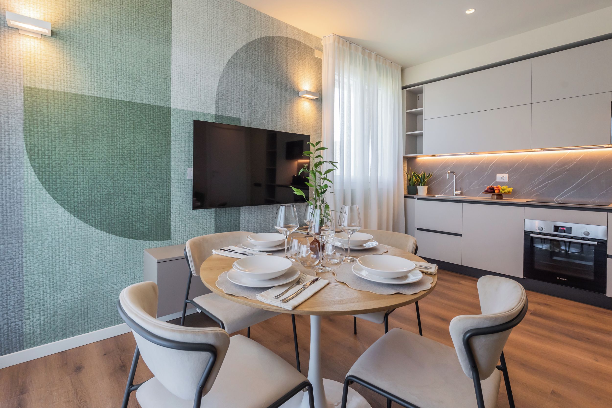 Een moderne eethoek met een ronde tafel voor vier personen, omringd door stoelen.