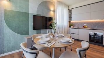 Een moderne eethoek met een ronde tafel voor vier personen, omringd door stoelen.