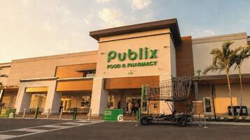 Un negozio Publix Food & Pharmacy con un grande cartello, un parcheggio e un carrello della spesa all'esterno.