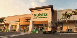 Un negozio Publix Food & Pharmacy con un grande cartello, un parcheggio e un carrello della spesa all'esterno.