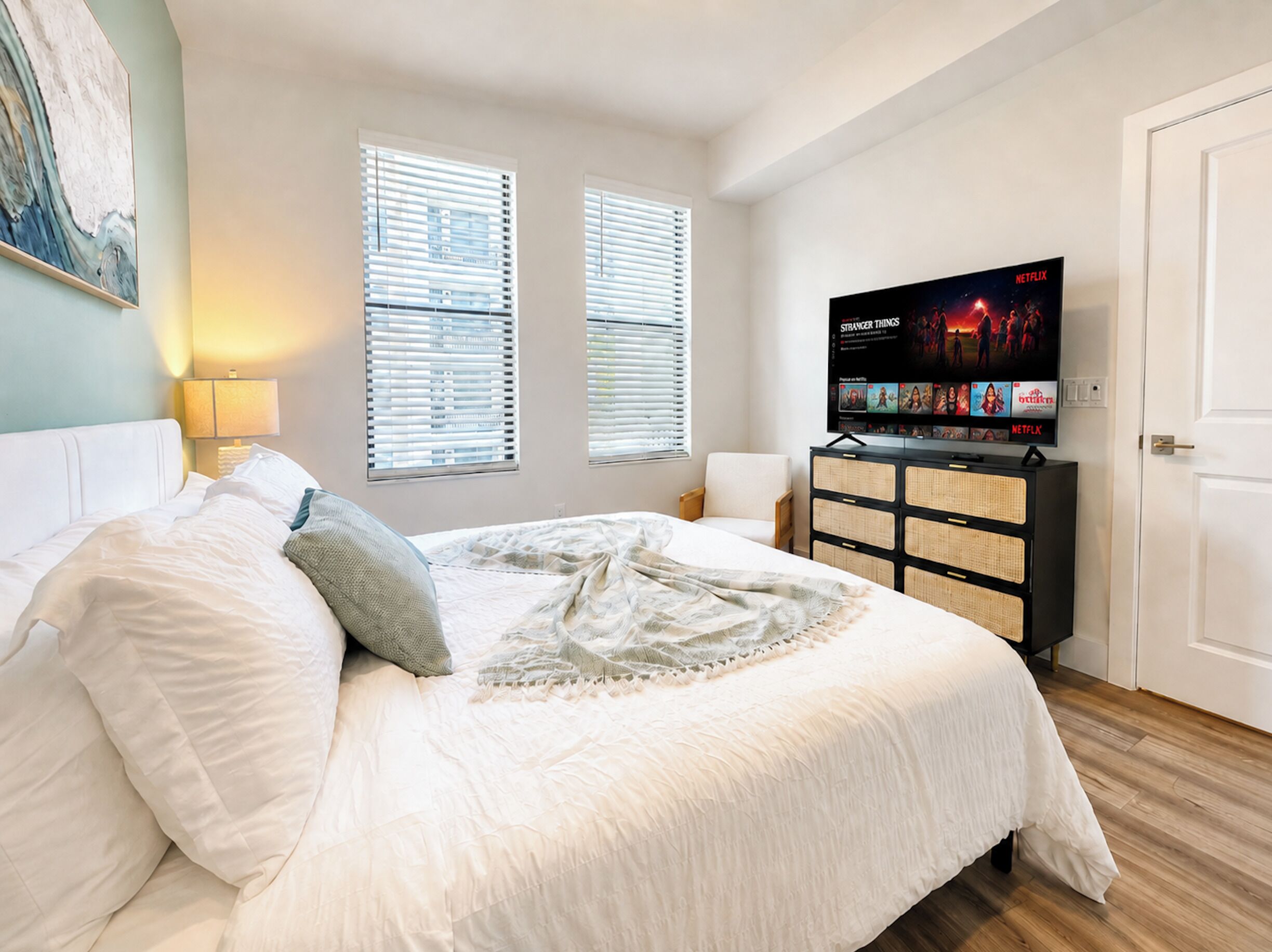 Una camera da letto con un letto, una televisione su un mobile e una porta.