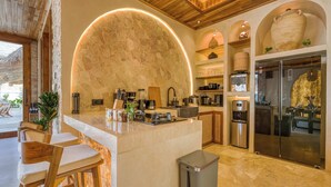 A modern kitchen with a large island, built-in appliances, and a stone accent wall. - Villa Provence, NEW 8BDR, Jacuzzi, Cinema, Luxury (Kabupaten Badung)