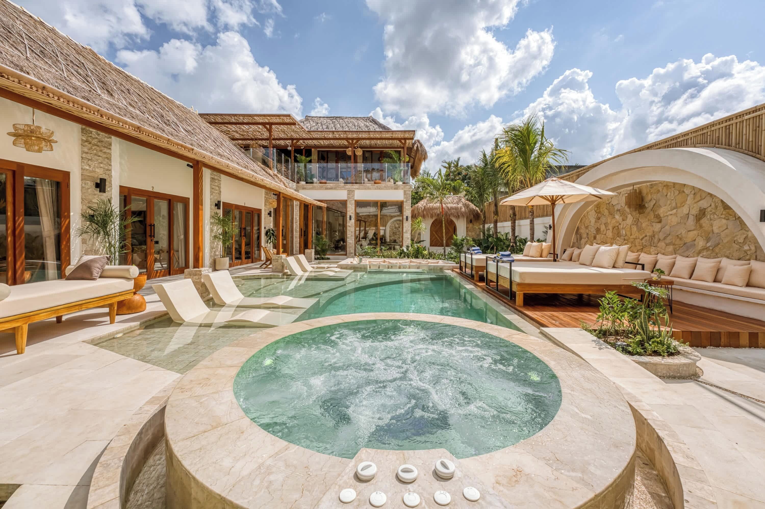 A resort with a swimming pool, a hot tub, and outdoor seating areas.