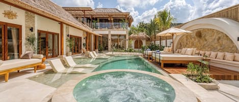 A resort with a swimming pool, a hot tub, and outdoor seating areas.