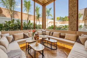 A spacious living area with a large window, a sofa set, and a coffee table. - Villa Provence – 8BDR, Jacuzzi, Cinema, Rooftop (Kabupaten Badung)