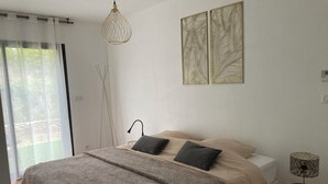 Um quarto com uma cama, abajur, luminária de chão e janela com cortinas.