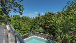 Ein Pool, umgeben von üppigem Grün und blauem Himmel.
