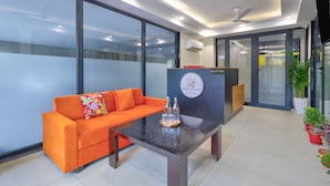 A reception area with a reception desk, a sofa, and a coffee table. - Urban Alcove Executive Suites by Luxe 8 (Gurugram)