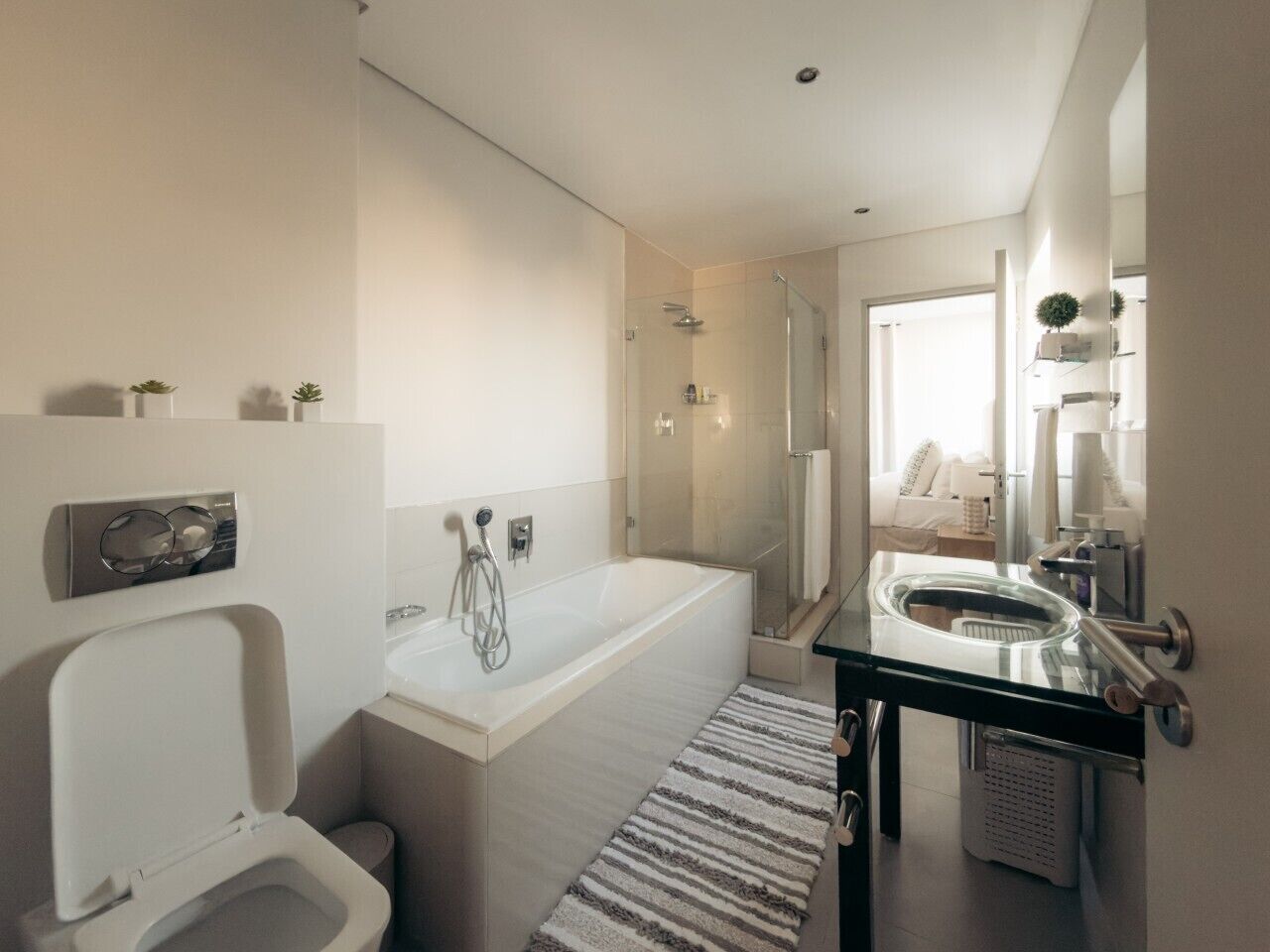 Een moderne badkamer met bad, toilet en wastafel.