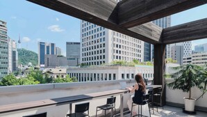 Una terrazza sul tetto con vista sulla città, tra cui una torre e diversi edifici.