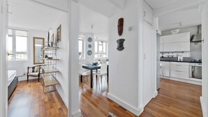 A spacious kitchen with modern appliances, a dining area with a table and chairs, and a living area with a sofa and a coffee table. - Airy 1BD Flat with Balcony, Battersea (Greater London)