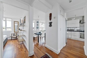 A spacious kitchen with modern appliances, a dining area with a table and chairs, and a living area with a sofa and a coffee table. - Airy 1BD Flat with Balcony, Battersea (Greater London)