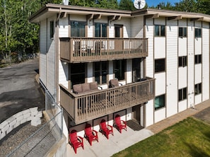 A two-story building with a balcony on the upper level, featuring outdoor seating and a fenced area. - Aurora Skyline Lodge (North Pole)