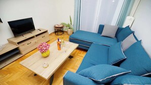 Ein modernes Wohnzimmer mit einer Couch, einem Couchtisch und einem Fernseher.