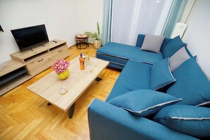 Ein modernes Wohnzimmer mit einer Couch, einem Couchtisch und einem Fernseher.