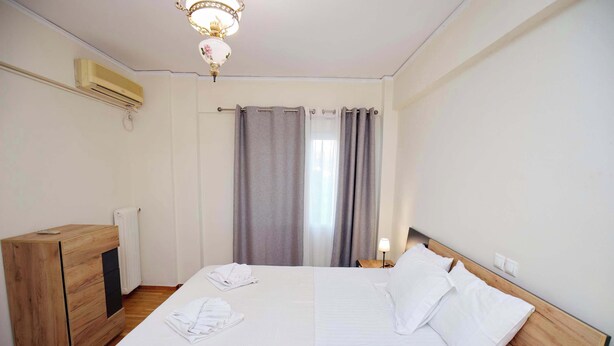 Ein Hotelzimmer mit einem Bett, einem Holzschrank, einem Heizkörper und einer Kristallleuchter.