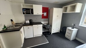 Eine kleine Küchenzeile mit Mikrowelle, Toaster und Spüle.
