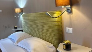 A hotel room with a bed, a nightstand, a lamp, and a wall-mounted air conditioning unit. - La Rocca Guest House & SPA - Family Superior Room 2 (Montefalco)