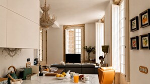 A modern kitchen with a marble countertop, a dining area with a sofa, and a chandelier. - Genteel Home Casa Leal de Ibarra (Almeria)
