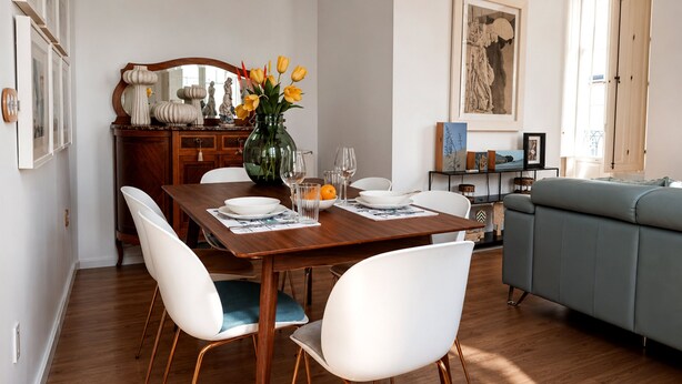 A dining area with a wooden table, white chairs, and a vase with yellow flowers. - Genteel Home Casa Leal de Ibarra (Almeria)