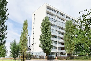 A multi-story building with a flat facade, surrounded by trees and a clear sky. - Spacious T4 Apartment with Mountain Views, Wi-Fi, and Parking – Sleeps 8 in Annecy (Annecy)