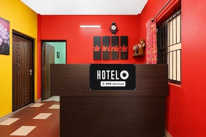 Un comptoir d’accueil d’hôtel avec une pancarte indiquant que l’établissement est géré par OYO.