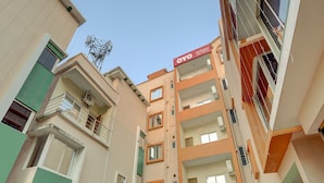 A multi-story residential building with balconies, air conditioning units, and a visible antenna on the roof. - Classic Avisi Residency (Bhubaneshwar)