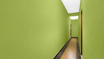 A hallway with green walls and a wooden floor.