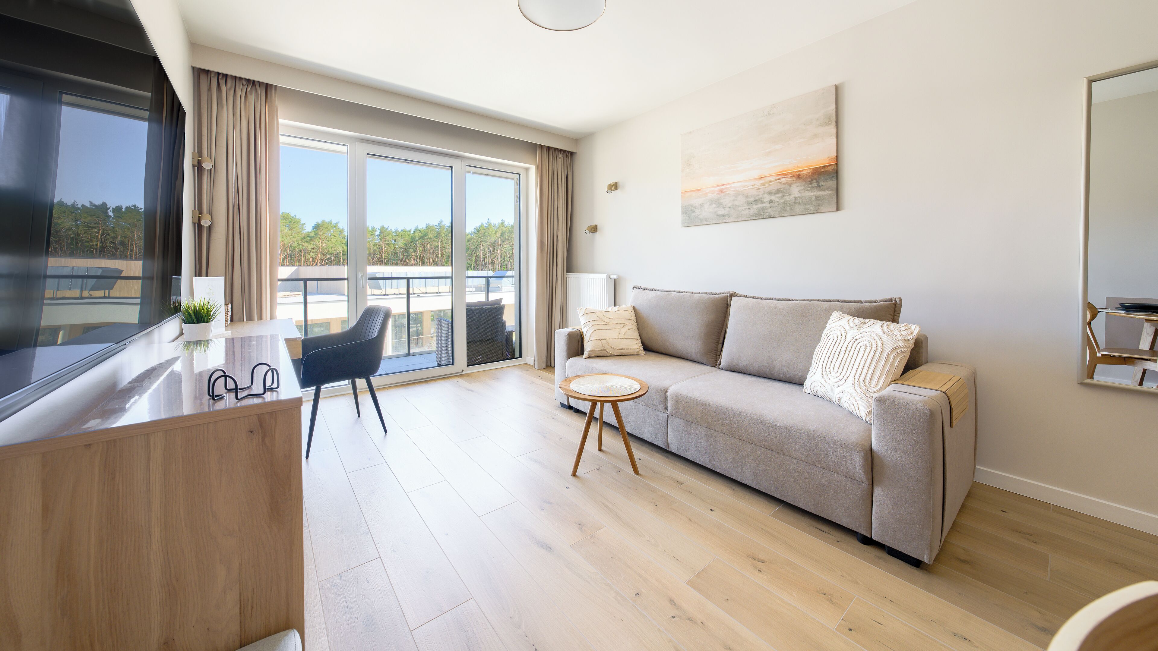 A modern living room with a sofa, a small round table, and a chair.
