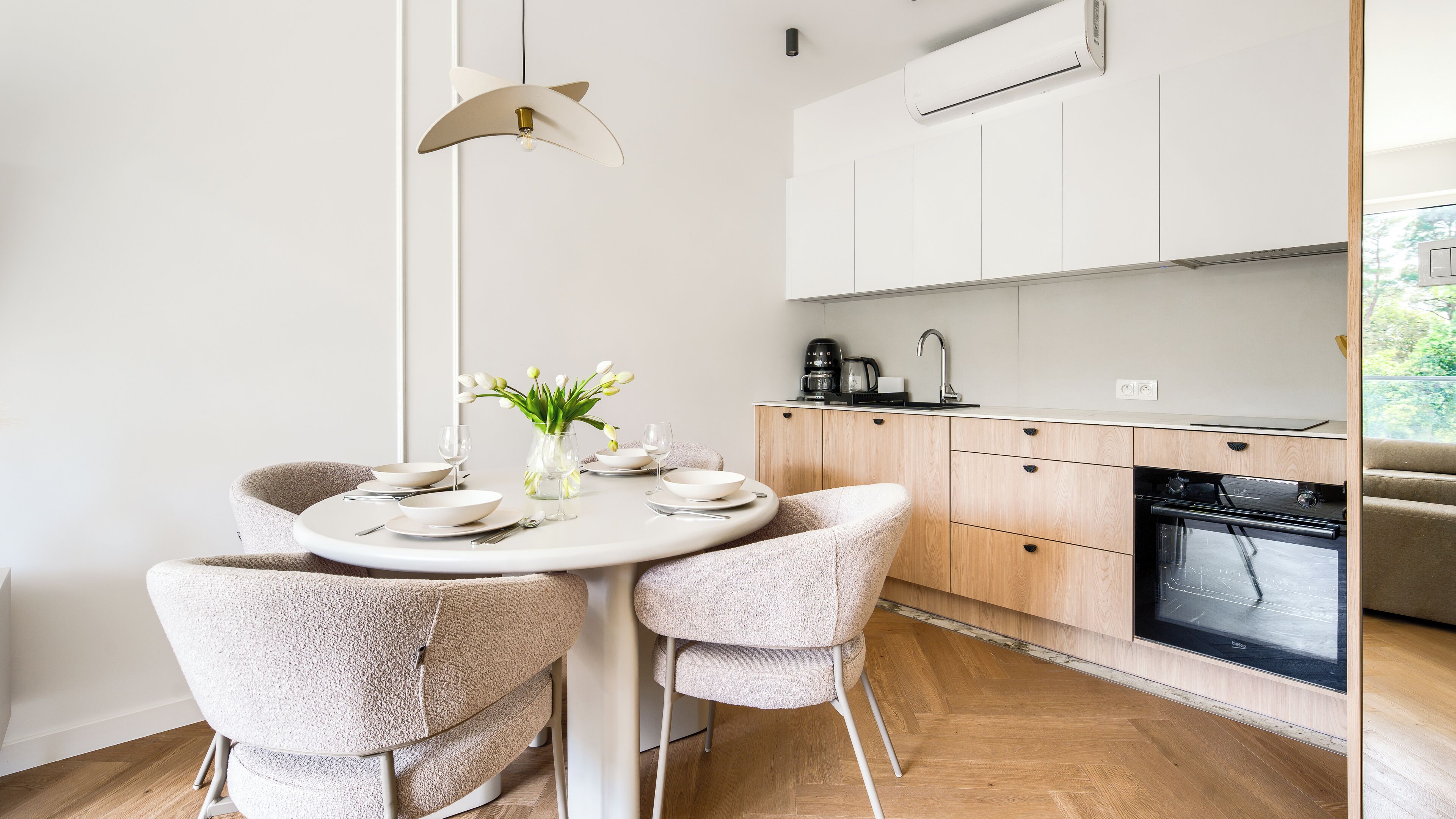 Una cocina moderna con horno empotrado, cafetera y lavabo.