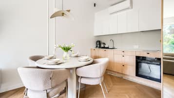 Una cocina moderna con horno empotrado, cafetera y lavabo.